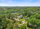 Aerial view of a neighborhood with tree coverage and the city skyline in the distance at 3034 Lewis Farm Rd, Raleigh, NC 27607