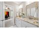 Bathroom featuring dual sinks, granite countertops, white cabinetry, and a doorway to another room at 3034 Lewis Farm Rd, Raleigh, NC 27607