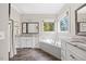 Bathroom featuring dual sinks, granite countertops, and a soaking tub with tiled surround at 3034 Lewis Farm Rd, Raleigh, NC 27607