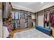 Spacious walk-in closet with custom shelving, a soft area rug and a storage bench at 3034 Lewis Farm Rd, Raleigh, NC 27607
