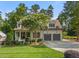Charming home boasts a well-manicured lawn, flowering tree, and convenient two-car garage at 3034 Lewis Farm Rd, Raleigh, NC 27607