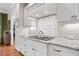 Stylish kitchen featuring granite countertops, white cabinets, and a decorative backsplash above the cooktop at 3034 Lewis Farm Rd, Raleigh, NC 27607