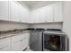 Functional laundry room with ample cabinet space, granite countertop, and modern appliances at 3034 Lewis Farm Rd, Raleigh, NC 27607