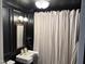Modern bathroom with sleek black walls, pedestal sink, and stylish fixtures at 313 W Noble St, Louisburg, NC 27549