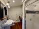 Cozy bathroom featuring a pedestal sink, walk-in shower, neutral tones, and wood floors at 313 W Noble St, Louisburg, NC 27549