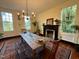 Traditional dining room with fireplace, wooden table set for dinner, and large windows offering outdoor views at 313 W Noble St, Louisburg, NC 27549