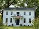 Beautiful two-story white home with a balcony, columns, and American flag at 313 W Noble St, Louisburg, NC 27549