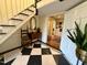 Foyer with checkerboard tile, wooden stairs, and antique accents creating a welcoming and stylish entrance at 313 W Noble St, Louisburg, NC 27549