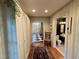 Inviting hallway featuring hardwood floors, built-in storage, and views of the entryway and bathroom at 313 W Noble St, Louisburg, NC 27549