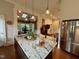 Open kitchen island with granite countertop, stainless steel refrigerator, and pendant lighting at 313 W Noble St, Louisburg, NC 27549