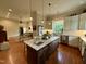 Open kitchen with granite countertops, island with seating, and stainless steel appliances at 313 W Noble St, Louisburg, NC 27549