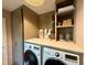 Well-organized laundry room with front-load washer and dryer and ample storage at 313 W Noble St, Louisburg, NC 27549