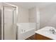 Bright bathroom featuring a tiled shower, soaking tub, double sinks, and hardwood floors at 330 Gilman Ln # 109, Raleigh, NC 27610