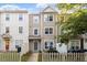 Three-story townhouse with neutral siding, white trim, and a small fenced front yard at 330 Gilman Ln # 109, Raleigh, NC 27610