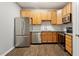 Modern kitchen featuring stainless steel appliances, granite countertops, tile backsplash, and wooden cabinets at 330 Gilman Ln # 109, Raleigh, NC 27610