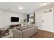 Staged living room with hardwood floors, sofa, television, and neutral tones at 330 Gilman Ln # 109, Raleigh, NC 27610