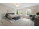 Staged main bedroom with bench, sitting area, and bright windows at 330 Gilman Ln # 109, Raleigh, NC 27610