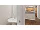 Modern powder room with pedestal sink, decorative mirror, and tile flooring, offering a sleek and functional design at 330 Gilman Ln # 109, Raleigh, NC 27610