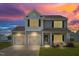 Two-story home featuring three-car garage, manicured lawn, and charming front porch under a colorful sky at 341 Henry Steel Dr, Gibsonville, NC 27249