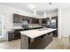 A lovely kitchen featuring dark cabinets, stainless appliances, and a center island with a double sink at 341 Henry Steel Dr, Gibsonville, NC 27249