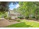 A spacious backyard with a well manicured lawn, mature trees, and a patio area at 3705 Old Post Rd, Raleigh, NC 27612