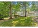 Backyard view featuring well manicured lawn, mature trees and a porch at 3705 Old Post Rd, Raleigh, NC 27612