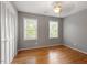 This is a bedroom with hardwood floors, two windows, and a ceiling fan light at 3705 Old Post Rd, Raleigh, NC 27612