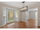 Dining room with hardwood floors and modern chandelier next to bay window at 3705 Old Post Rd, Raleigh, NC 27612