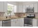 Well-lit kitchen features white cabinets, stainless steel appliances, and granite countertops at 3705 Old Post Rd, Raleigh, NC 27612