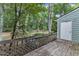 View of the wooden deck, a storage shed, and a wooded backyard with lush trees at 410 Oak Run Dr, Raleigh, NC 27606