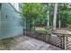 Weathered wooden back deck with latticework railing, providing a tranquil outdoor space surrounded by lush greenery at 410 Oak Run Dr, Raleigh, NC 27606