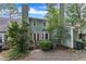 Back exterior view of a home, showcasing a green backyard, a wood deck, and beautiful landscaping at 410 Oak Run Dr, Raleigh, NC 27606