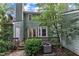 Back exterior view of a home with a wooden deck, lush greenery, and a well-maintained HVAC unit at 410 Oak Run Dr, Raleigh, NC 27606