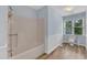 Bright bathroom featuring vinyl flooring, white tub, toilet with a window, and light blue walls at 410 Oak Run Dr, Raleigh, NC 27606