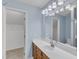 Well-lit bathroom featuring a modern vanity, framed mirror, and an organized walk-in closet for ample storage at 410 Oak Run Dr, Raleigh, NC 27606