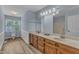 Bright bathroom with double vanity, wood-look floors, and light blue walls and wainscotting at 410 Oak Run Dr, Raleigh, NC 27606