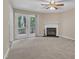 Bright living room featuring a cozy fireplace and patio access to the outdoors at 410 Oak Run Dr, Raleigh, NC 27606