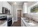 Bright kitchen featuring white cabinets, granite counters, stainless appliances, and modern fixtures at 413 E Center St, Nashville, NC 27856
