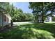 Expansive backyard with mature trees, playset, and lush lawn, offering privacy and space for outdoor activities at 4217 Grahamstone Rd, Raleigh, NC 27610