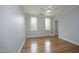 Bedroom with hardwood floors, fan, and door to balcony at 4217 Grahamstone Rd, Raleigh, NC 27610
