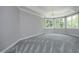Bedroom with a tray ceiling, hardwood floors, large windows, and neutral color palette at 4217 Grahamstone Rd, Raleigh, NC 27610