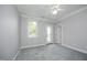 Cozy bedroom with gray carpet, ceiling fan, and natural light at 4217 Grahamstone Rd, Raleigh, NC 27610