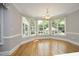 Dining room boasts hardwood floors, large windows, and elegant chandelier at 4217 Grahamstone Rd, Raleigh, NC 27610