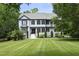 A charming two-story home with a landscaped yard featuring a well-manicured lawn and lush greenery at 4217 Grahamstone Rd, Raleigh, NC 27610