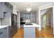 Stylish kitchen with gray cabinetry, stainless steel appliances, and a center island, perfect for cooking at 4217 Grahamstone Rd, Raleigh, NC 27610