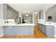Modern kitchen with gray cabinets, quartz countertops, stainless steel appliances, and stylish lighting fixtures at 4217 Grahamstone Rd, Raleigh, NC 27610