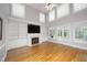 Spacious living room with a fireplace, built-in bookshelves, and large windows providing ample natural light at 4217 Grahamstone Rd, Raleigh, NC 27610