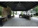Covered outdoor kitchen featuring a stone fireplace, built-in grill, and spacious bar top for entertaining at 4217 Grahamstone Rd, Raleigh, NC 27610