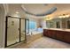 Bright bathroom featuring a soaking tub, walk-in shower, double vanity and tiled floors at 502 Willowmere Ct, Cary, NC 27513