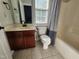 Functional bathroom with a wood vanity, toilet, and combined tub and shower with a patterned curtain at 502 Willowmere Ct, Cary, NC 27513